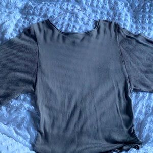 It’s an elegant blouse for women. The brand is Apt.